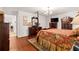 This main bedroom features a wood floor, a dark wood furniture set, and a decorative floral bedspread at 5445 Ne Anthony Rd, Ocala, FL 34475