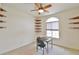 Neutral bedroom features a ceiling fan, a window, and custom corner shelving at 5551 Nw 25Th Loop, Ocala, FL 34482