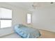 This bedroom features neutral carpet, a ceiling fan, and bright natural light at 5551 Nw 25Th Loop, Ocala, FL 34482