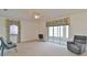 Bright living room with neutral carpeting, large windows, and sliding glass doors to the lanai at 5551 Nw 25Th Loop, Ocala, FL 34482