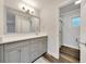 Bathroom vanity featuring a large mirror and a doorway leading to the shower and toilet at 616 Se 40Th Ave, Ocala, FL 34471