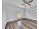 Bright bedroom offers wood-look flooring, neutral paint, closet, and two windows for natural light at 616 Se 40Th Ave, Ocala, FL 34471