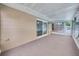 View of the carpeted sunroom with sliding glass door access to the pool at 616 Se 40Th Ave, Ocala, FL 34471