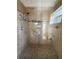Tiled shower with glass door, featuring mosaic accents and accessible handrails, promoting safety and elegance at 6241 Sw 84Th Pl, Ocala, FL 34476