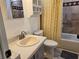 Bathroom featuring a vanity sink, toilet, and a shower/tub combo with patterned yellow shower curtain at 741 Truman Ave, Lady Lake, FL 32159