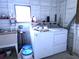 Bright laundry room with a washer, dryer, utility sink, and shelving for storage at 741 Truman Ave, Lady Lake, FL 32159