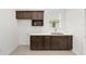 Bright laundry room features dark brown cabinetry, white countertop, and window at 7513 Sw 56Th Pl, Ocala, FL 34474