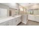 Bathroom with double vanities, framed mirrors, white cabinetry and a glass-enclosed shower at 7745 Sw 56Th Pl, Ocala, FL 34474
