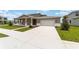 Inviting home with a large driveway leading to a two-car garage and a well-maintained front yard at 7745 Sw 56Th Pl, Ocala, FL 34474