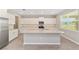 Bright kitchen featuring white cabinets, stainless steel appliances, and a large center island with granite countertops at 7745 Sw 56Th Pl, Ocala, FL 34474