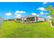 Expansive backyard featuring a lush lawn, landscaping, and a screened-in patio, perfect for outdoor enjoyment at 7891 Sw 89Th Cir, Ocala, FL 34481
