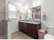 Updated bathroom features a large mirror, dual sinks with granite counters, and a walk-in shower for a modern feel at 7891 Sw 89Th Cir, Ocala, FL 34481