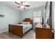 Cozy bedroom with natural light, wood furniture, and a ceiling fan offers a comfortable and inviting atmosphere at 7891 Sw 89Th Cir, Ocala, FL 34481
