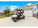 Golf cart on driveway in front of a two-car garage at 7891 Sw 89Th Cir, Ocala, FL 34481