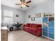 Versatile bonus room with a red couch and organized storage, perfect for an office or entertainment area at 7891 Sw 89Th Cir, Ocala, FL 34481