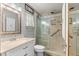 This bathroom boasts a vanity, commode, a glass shower with a handrail and modern fixtures at 8625 Sw 94Th Ln # A, Ocala, FL 34481