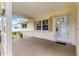 Covered porch featuring a decorative white railing and partial view of manicured yard at 8625 Sw 94Th Ln # A, Ocala, FL 34481