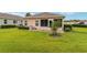 Green backyard features a screened-in porch with landscaped shrubs and a well manicured lawn at 8670 Se 141St Pl, Summerfield, FL 34491