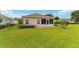 Exterior view showcasing the lush backyard, screened lanai, and well-maintained landscaping at 8670 Se 141St Pl, Summerfield, FL 34491