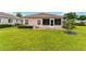 Manicured backyard with a well-maintained lawn, lush landscaping, and a charming patio area at 8670 Se 141St Pl, Summerfield, FL 34491