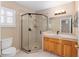 Bathroom featuring a glass enclosed shower, wood vanity, and large mirror at 8670 Se 141St Pl, Summerfield, FL 34491