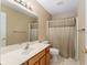 Bathroom featuring vanity, toilet, mirror and shower with curtain at 8670 Se 141St Pl, Summerfield, FL 34491