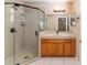 Bathroom featuring a glass enclosed shower, wood vanity, and large mirror at 8670 Se 141St Pl, Summerfield, FL 34491