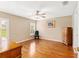Bright bedroom with wood floors, ceiling fan, shuttered windows and a classic wooden dresser at 8670 Se 141St Pl, Summerfield, FL 34491