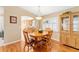Dining room with wood flooring and view of the kitchen through an arched doorway at 8670 Se 141St Pl, Summerfield, FL 34491