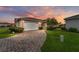 Charming home featuring a brick driveway, attached garage, manicured lawn, and beautiful landscaping at 8670 Se 141St Pl, Summerfield, FL 34491