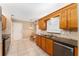 Charming kitchen with granite countertops, wooden cabinets, and tile flooring at 8670 Se 141St Pl, Summerfield, FL 34491