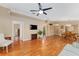 Open living room showcasing hardwood floors, ceiling fan, and access to multiple rooms at 8670 Se 141St Pl, Summerfield, FL 34491