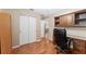 Office featuring built-in desk and shelving, wood floors and closet at 8670 Se 141St Pl, Summerfield, FL 34491