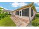 Enclosed back patio area with screened windows and brick paver flooring at 8670 Se 141St Pl, Summerfield, FL 34491