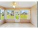 Cozy sunroom with abundant natural light and tile floors overlooks a well-manicured backyard at 8670 Se 141St Pl, Summerfield, FL 34491