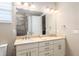 Bathroom featuring double vanity with granite countertop, large mirror, and modern fixtures and accessible shower at 8878 Sw 103Rd Cir, Ocala, FL 34481
