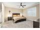 Cozy bedroom featuring a ceiling fan, neutral paint, carpet, and a large window for natural light at 8878 Sw 103Rd Cir, Ocala, FL 34481
