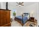 Cozy bedroom features wood-look flooring, a ceiling fan, and natural light at 8989 Sw 57Th Place Rd, Ocala, FL 34481
