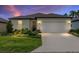 Charming single-story home with a well-manicured lawn and a two-car garage at twilight at 8989 Sw 57Th Place Rd, Ocala, FL 34481