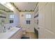 Clean bathroom featuring a vanity, toilet, shower, and golf-themed wallpaper accents at 9486 Se 173Rd Pl, Summerfield, FL 34491