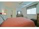 Bedroom with large bed, ceiling fan, and a view into the bathroom and hallway at 9486 Se 173Rd Pl, Summerfield, FL 34491