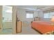 Bedroom featuring a ceiling fan, a bed with a red comforter, and an ensuite bathroom at 9486 Se 173Rd Pl, Summerfield, FL 34491