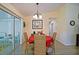 Bright dining room featuring wicker chairs, a red table cloth, and a sliding glass door to the lanai at 9486 Se 173Rd Pl, Summerfield, FL 34491