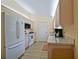 Well-lit kitchen featuring wood cabinets, appliances, and light countertops, adjacent to a door to the lanai at 9486 Se 173Rd Pl, Summerfield, FL 34491