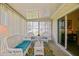 Bright sunroom featuring wicker furniture, a colorful rug, and sliding glass doors to the main house at 9486 Se 173Rd Pl, Summerfield, FL 34491