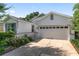 A daytime view of the home's exterior showing the driveway, garage, and surrounding landscaping at 9805 Sw 95Th Loop, Ocala, FL 34481