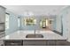 Bright kitchen featuring a large center island with stone countertops, stainless steel appliances, and views to the backyard at 9805 Sw 95Th Loop, Ocala, FL 34481