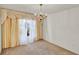 Bedroom with carpet, large window, decorative curtains, and chandelier lighting at 9952 Sw 58Th Ave, Ocala, FL 34476