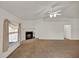 Bright living room showcasing carpet, a fireplace, a ceiling fan, and neutral walls at 9952 Sw 58Th Ave, Ocala, FL 34476