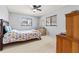 Bedroom featuring a colorful floral bedspread, neutral carpeting, and bright natural light at 10210 Sw 93Rd Ave, Ocala, FL 34481